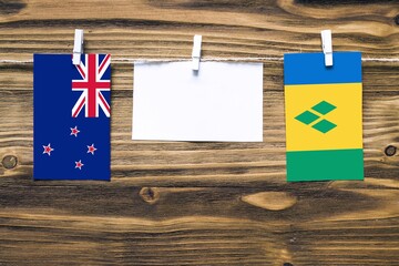 Hanging flags of New Zealand and Saint Vincent And The Grenadines attached to rope with clothes...