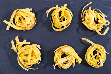 the Pasta nests on the black stone board ready to cook and taste with the ingredients of your choice.