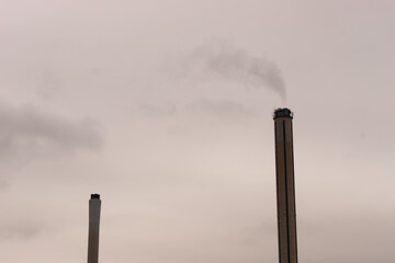 polluting chimneys with gray clouds in background