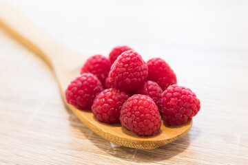 wooden spoon with natural red raspberries
