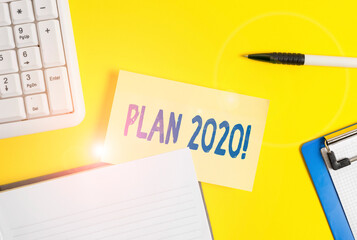 Word writing text Plan 2020. Business photo showcasing detailed proposal doing achieving something next year Empty orange paper with copy space on the yellow table