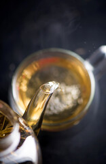Tea concept, teapot with tea surrounded on wood background