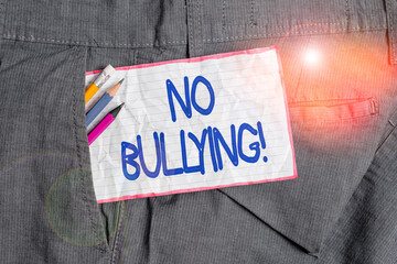 Text sign showing No Bullying. Business photo text stop aggressive behavior among children power imbalance Writing equipment and white note paper inside pocket of man work trousers