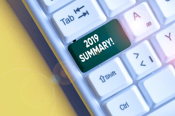Conceptual hand writing showing 2019 Summary. Concept meaning summarizing past year events main actions or good shows White pc keyboard with note paper above the white background
