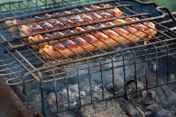 Close-up of fried sausages on the grill. Concept: outdoor recreation, baker, holiday.