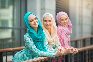 three beautiful young women in muslim dresses