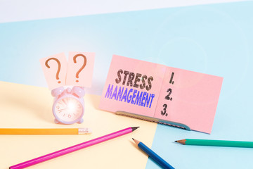 Conceptual hand writing showing Stress Management. Concept meaning method of limiting stress and its effects by learning ways Mini size alarm clock beside stationary on pastel backdrop