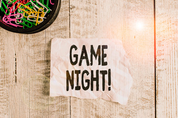 Conceptual hand writing showing Game Night. Concept meaning usually its called on adult play dates like poker with friends Wrinkle paper and cardboard placed above wooden background