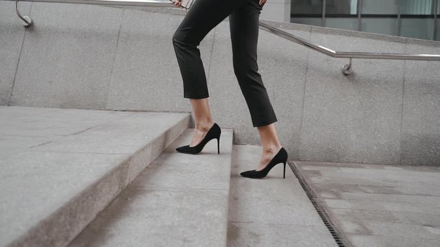 Young adult business lady walking on stairs