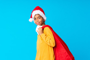 African American boy with christmas hat and taking a bag with gifts