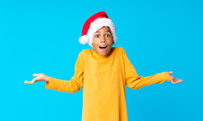 Obraz premium African American boy with christmas hat with shocked facial expression