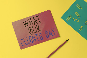 Writing note showing What Our Clients Say. Business concept for testimonials or feedback of aclient about the product Blank paper sheets message pencil clips binder plain colored background