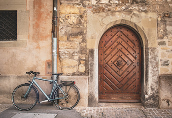 Fototapeta na wymiar Old meets new. Brick building wall with old vintage wood door and bicycle. Soft light. Town Hall (Rathaus) Luzern, Switzerland