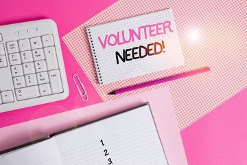 Writing note showing Volunteer Needed. Business concept for need work for organization without being paid Writing equipments and computer stuffs placed above colored plain table