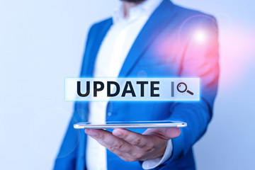 Conceptual hand writing showing Update. Concept meaning make something more modern or up to date like software programs Man in blue suite and white shirt holds mobile phone in hand