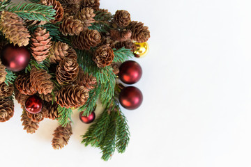 Christmas fir branch with pine cones and red yellow balls