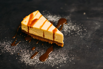 Pastry and dessert. Closeup of New York cheesecake with syrup and sugar powder. Copy space. - obrazy, fototapety, plakaty