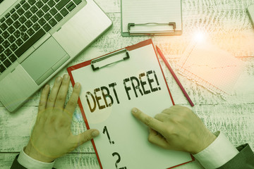Text sign showing Debt Free. Business photo text does not owning any money to any individual or companies Hand hold writing equipment tool near modern high technology laptop device