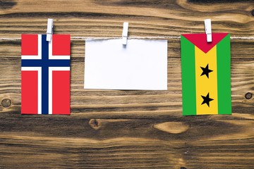Hanging flags of Norway and Sao Tome And Principe attached to rope with clothes pins with copy...