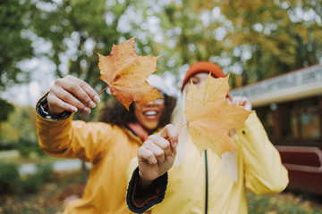 Two pretty women holding leaves in hands