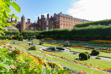 Georgianische und Tudor-Fassaden des Hampton Court Palace mit dem Vordergrund, der die bunten versunkenen Gärten zeigt