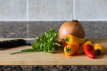 knife and vegetables on wooden background