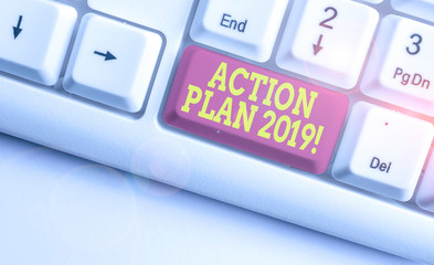 Text sign showing Action Plan 2019. Business photo text proposed strategy or course of actions for current year White pc keyboard with empty note paper above white background key copy space