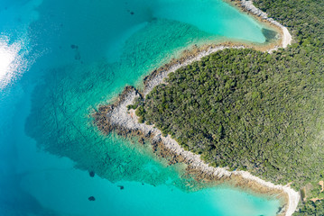 Fototapeta na wymiar Aerial view of sea and beach in a lagoon on Cres ( isola Cherso ) Island Croatia, close to Punta Kriza ( Punta Croce ). It is a part of national where rocks and sand and forest merge on a coast. 