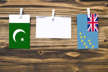 Hanging flags of Pakistan and Tuvalu attached to rope with clothes pins with copy space on white...