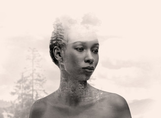 Triple exposure of young African-American woman, clouds and forest landscape