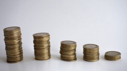 Consuming and decrease concept with metal coins isolated on white background. Spending money for...