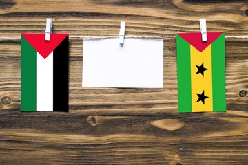 Hanging flags of Palestine and Sao Tome And Principe attached to rope with clothes pins with copy...