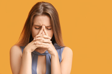 Stressed young woman on color background