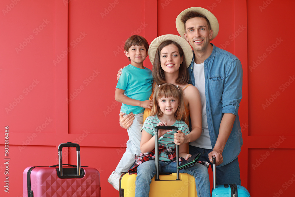 Wall mural Happy family with luggage on color background