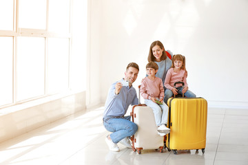 Happy family with luggage taking selfie in airport