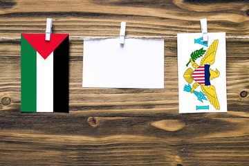 Hanging flags of Palestine and United States Virgin Islands attached to rope with clothes pins with...