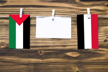 Hanging flags of Palestine and Yemen attached to rope with clothes pins with copy space on white...