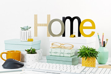 Home office concept with flowers in the pots and office supply, computer keyboard and mouse