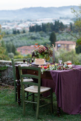 Beautiful and elegant table setting for a romantic date for a couple. Private terrace outside the restaurant. Italian landscape on background. Italy, Tuscany