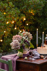 Beautiful and elegant table setting for a romantic date for a couple. Private terrace outside the restaurant. Lights on background