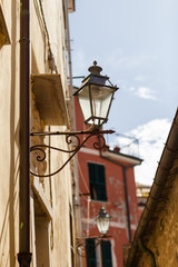 Fototapeta na wymiar Italy, Liguria region, Cinque Terre national resort. Small street with lamp. Bright colorful walls, sunny day