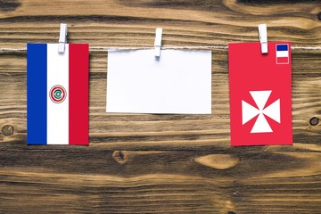 Hanging flags of Paraguay and Wallis And Futuna attached to rope with clothes pins with copy space...