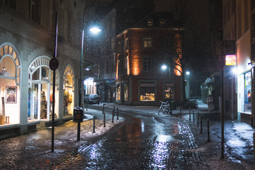Snowy empty street at night in Aachen, Germany