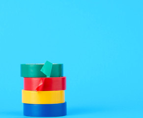 full coils of multi-colored insulating tape on a blue background