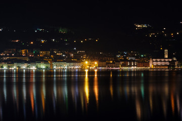Fototapeta na wymiar Evening panoramic view of the center of Salo Lake Garda. City night lights reflected in water