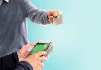 Man pays with credit card with pos in color background. sale purchase concept with credit card