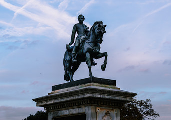 Obraz premium Monumento de un hombre a caballo con cielo de nubes azulado
