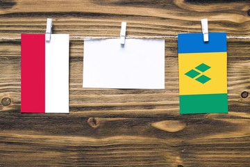 Hanging flags of Poland and Saint Vincent And The Grenadines attached to rope with clothes pins...