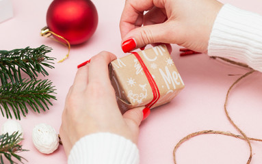 handmade gift wrapping and decorating a gift wrapped in festive paper with the inscription Christmas