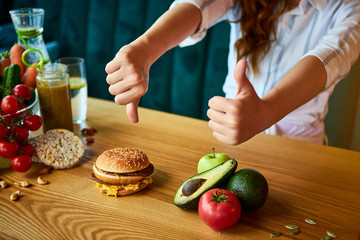 Woman is refusing to eat unhealthy hamburger. Cheap junk food vs healthy diet